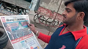 Gujarat Prints: Man reading Gujarati newspaper story of Barack Obama US presidential inauguration Bhavnagar Gujarat India
