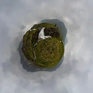man in red stands under waterfall on black rock in mountains on cloudy rainy day... Tiny little planet 360