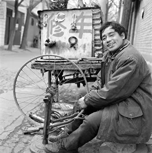 Alleyway Prints: A man repairing a bicycle in a Beijing hutong 2003 China