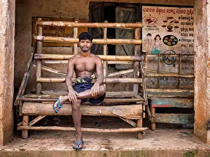 Village Life Prints: A man restring on a bench in a village in Odisha, India