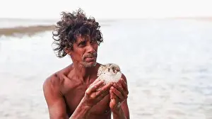 Admiration Prints: A man shows a pufferfish he has caught along the shores of Socotra