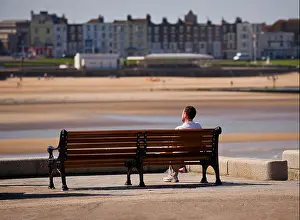 Margate Prints: A man sitting on a bench at the end of the Harbour Arm in Margate