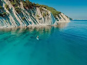 Paddleboard Prints: Man on stand up paddle board in blue sea in Mediterranean sea with scenic landscape