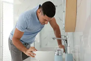 Inflammation Prints: Man suffering from nausea near sink in bathroom. Food poisoning