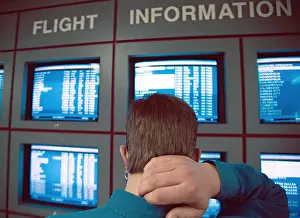 Difficulty Prints: A man surveys the flight arrival and departure board at the airport