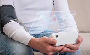 Check Up Prints: A man takes his blood pressure with an automatic device close up