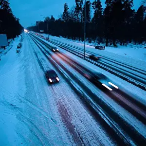 Eurasia Prints: Man takes a piss in February twilight on Kiev circle road without trying to step in snow as cars on winter tires are