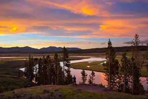 Mid Adult Man Prints: Man taking a photo at Yellowstone River in Hayden Valley at sunset