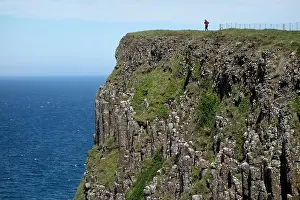 Man Walking above the Cliffs of Benbane Head on the Giant's Causeway Coastal Path, County Antrim, Northern Ireland, UK