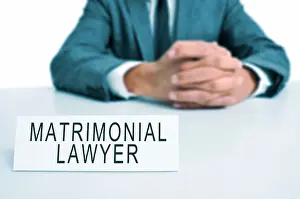 Laws Prints: a man wearing a suit sitting in a desk with a desktop nameplate in front of him with the text matrimonial lawyer