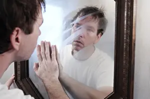 Wake Prints: A man wiping a foggy mirror while looking at his reflection in the mirror in the morning