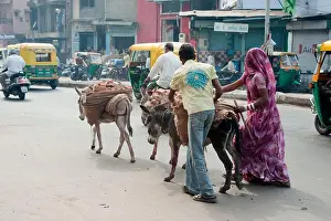 Villager Prints: Man and woman carrying brick on donkeys back ; Ahmedabad ; Gujarat ; India