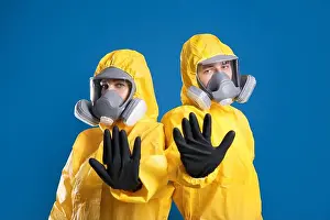 Suits Prints: Man and woman in chemical protective suits making stop gesture on blue background
