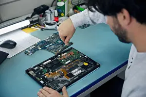 Craftsman Prints: A man is working on a motherboard with a magnifying glass