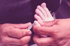 Femininity Prints: Manicurist using pliers to remove dead skin from around the client feet fingers