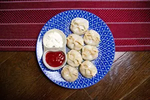 manti and sauce on a blue plate top view