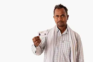 One Person Only Prints: A MANUAL LABOURER SHOWING AADHAR CARD IN FRONT OF CAMERA