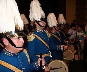 Seville Prints: Marching band dressed in blue military uniform with drummers at night and crowded street Seville Spain Easter 2014