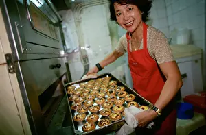 Asians Prints: Margaret of Margarets Café e Nata the best egg tarts in Macau pulls a tray of fresh eggs tarts from the oven