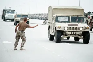 Shipment Prints: A Marine jokingly tries to hitch a ride on an M998 High-Mobility Multipurpose Wheeled Vehicle (HMMWV)