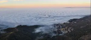 The marine layer, a moist air mass that develops over the ocean in the presence of a temperature inversion, seeps over the Bay Area in California