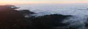The marine layer, a moist air mass that develops over the ocean in the presence of a temperature inversion, seeps over the Bay Area in California