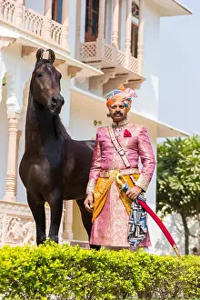 Marwari Horse. Man in traditional attire standing next to a bay stallion. Rajasthan, India