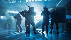 Masked Fireteam of Armed SWAT Police Officers Storm a Dark Seized Office Building with Desks and Computers