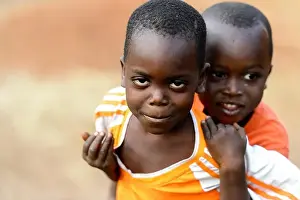 Nigeria Prints: MASSIF KABYE, TOGO - JAN 13, 2017: Unidentified Togolese little boy carries his friend in the village