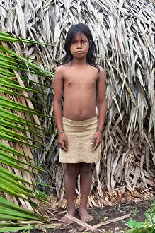 A Matses Mayorunas young girl in front of a maloca (traditional house), Amazonian Peru