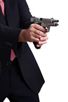 Alertness Prints: A mature adult man wearing suit holding 9mm gun both hands right in middle firing shot gun's latch in backwards