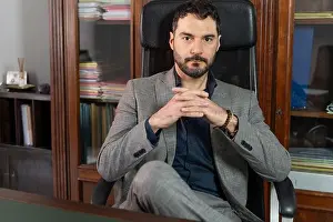 Contemplative Prints: Mature businessman sitting in leather chair at office