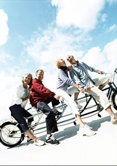 Caucasian Appearance Prints: Mature couples on tandem bike at beach, portrait