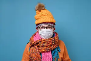 Fever Prints: Mature man with medical mask as protection from Covid-19 and funny hat glasses and scarf