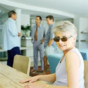 Brother Prints: Mature woman sitting at table, three men standing in background