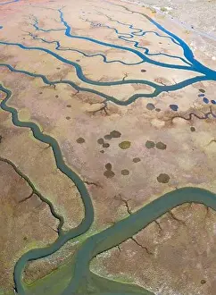Meandering channels run through a beautiful estuary in Central California. Estuaries form when freshwater runoff meets and mixes with seawater