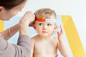 Measurement of the circumference of a 14-month-old baby's head (cranial perimeter) with a tape measure