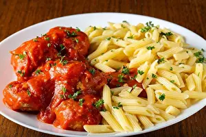 Romanian Prints: Meatballs in tomato sauce with small penne pasta on plate