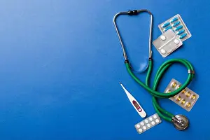 Thermometer Prints: Medical background. Many different various medicine tablets or pills on the table with stethoscope
