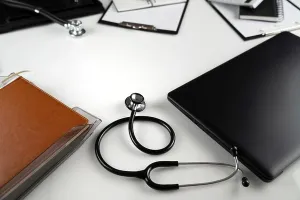 Judicial Prints: Medical law concept. Gavel, notebook and stethoscope on the glass table. Blue light