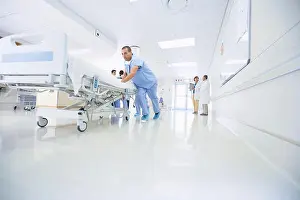 Urgency Prints: Medics urgently pushing hospital bed along corridor
