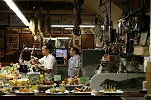 Bartender Prints: Two men selling pintxos inside a tapas bar in San Sebastian