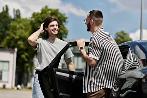 Intimacy Prints: Two men stand beside a car, smiling and talking