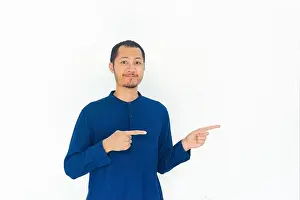 Satisfied Prints: Men wearing blue baju koko pointing to right with smile in isolated white background
