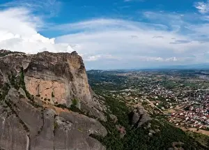 Thessaly Prints: Meteora Greece at sunrise, Blue sky with clouds over Monastery buildings on top of rocks and Kalambaka town and valley
