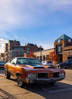 Business District Prints: Michigan, USA - October 24, 2021: A 1971 Oldsmobile 442 Cutlass Muscle Car parked on Main Street