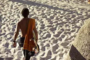 Surfboard Prints: Mid adult male surfer carrying surfboard on beach