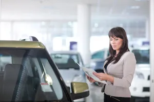 Differential Focus Prints: Mid adult woman checking car brochure in showroom