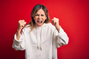 Fist Prints: Middle age beautiful sportswoman wearing casual sweatshirt over isolated red background angry