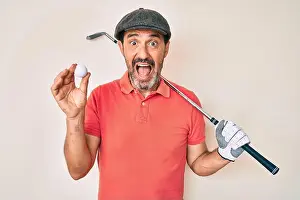 Golfing Prints: Middle age hispanic man holding golf club and ball celebrating crazy